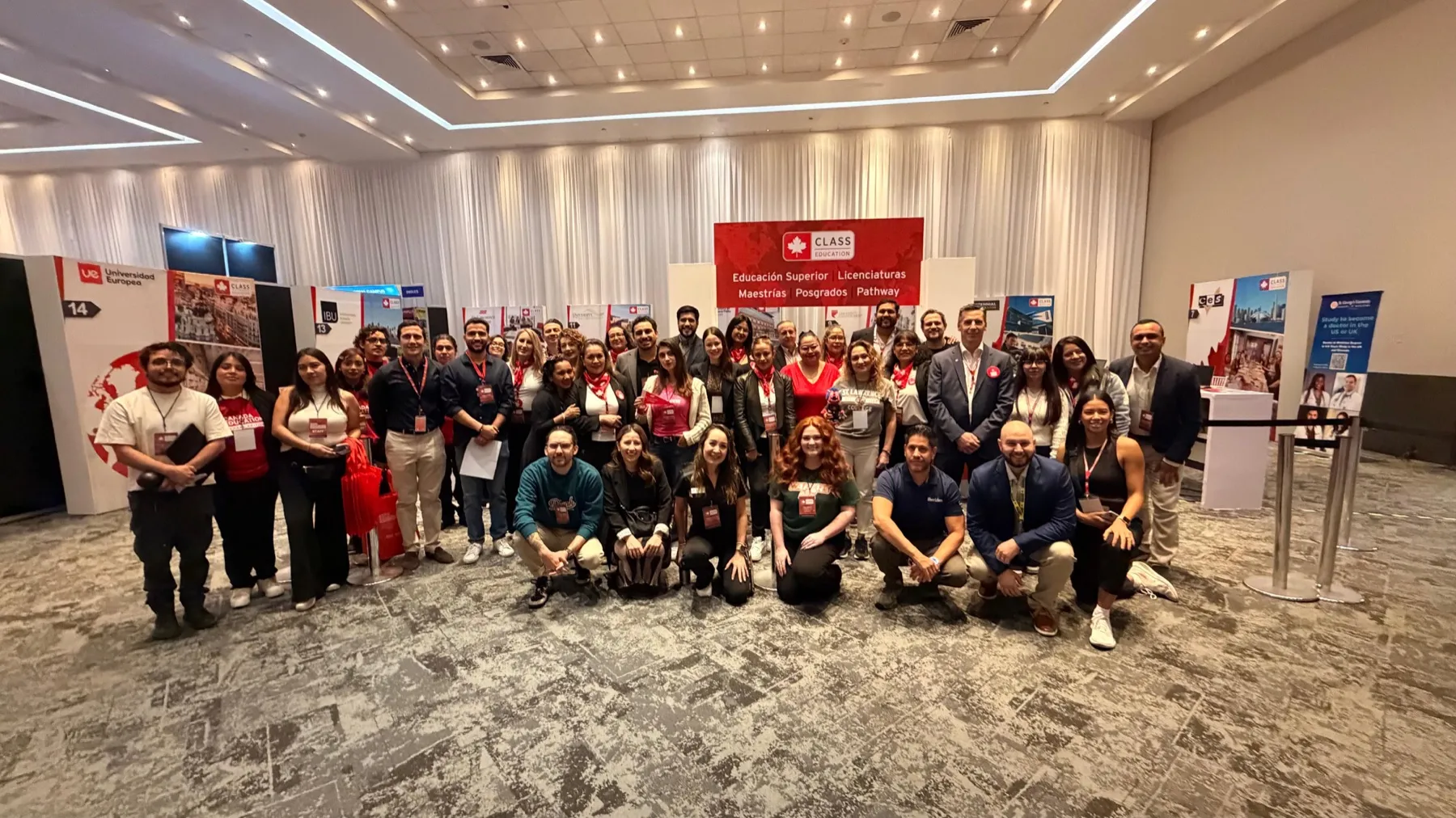 Foto de grupo del equipo de la expo y representantes de las instituciones, de pie y en cuclillas frente a los stands del salón.